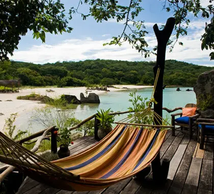 Una terraza de madera con hamaca y vistas a la playa: el lago Malawi es un paraíso tropical de playa en el corazón de África.