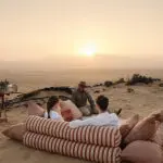 Tras un día explorando el paisaje, visitando lugares de arte rupestre local y disfrutando de paseos de safari, acomódese para una romántica puesta de sol.