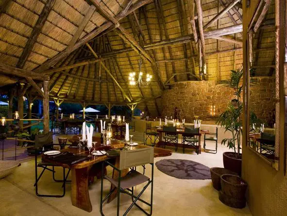 El comedor principal es cálido y acogedor bajo la paja, con vistas al aire libre.