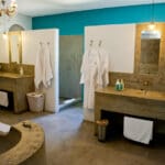 Algunos de los cuartos de baño son más abiertos, con duchas y lavabos dobles, y una gran bañera de cemento pulido fundido.