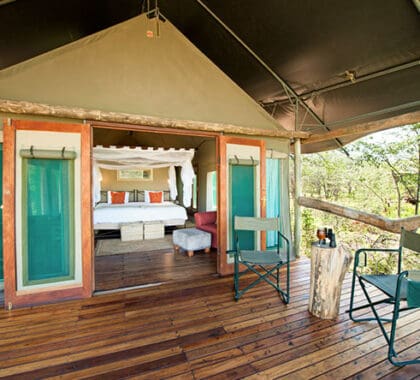 Double doors connect the suite's interior with its shaded wooden deck, complete with easy chairs.
