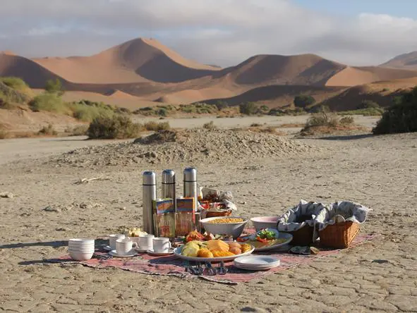 Disfrute de un romántico picnic al aire libre rodeado de la austera belleza del desierto de Namibia.