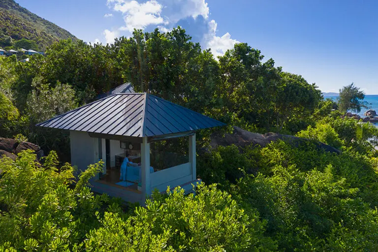 A secluded spa treatment room surrounded by island greenery.
