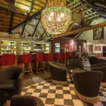 Sorseggiate un drink al bar ben fornito del lodge, che comprende una selezione di vini e gin sudafricani pregiati.