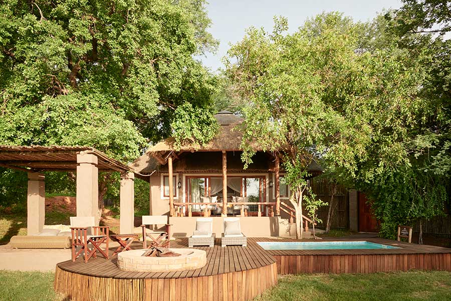 Una de las suites de Chobe Chilwero: una estructura de paja con porche que conduce a una plataforma de madera elevada con piscina y mini boma | Go2Africa