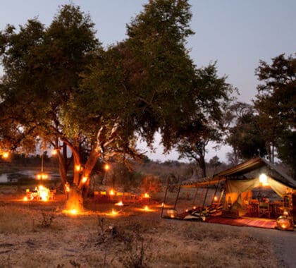 Por la noche, el salón ofrece un lugar de encuentro íntimo junto a la chimenea y entre el resplandor de las linternas.