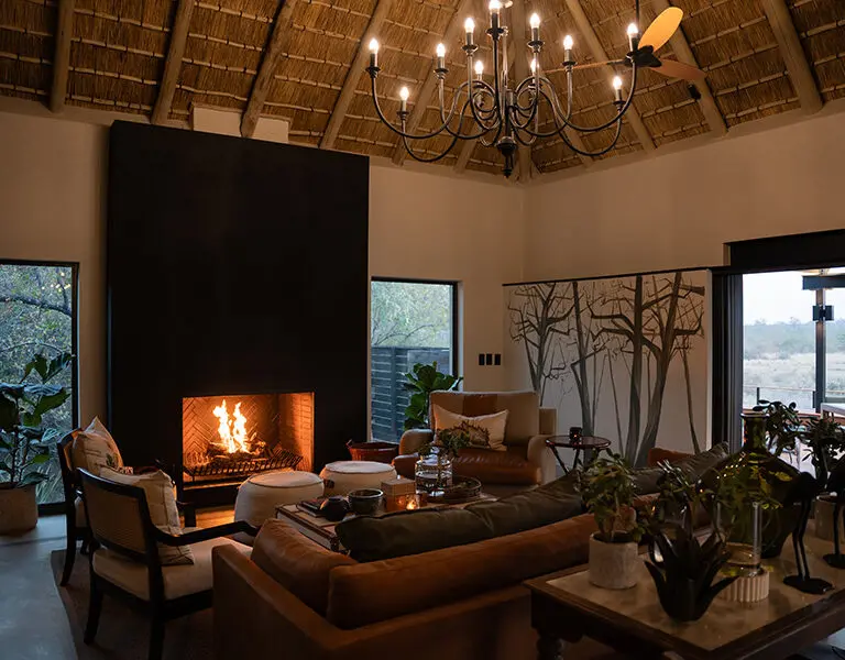 Relájese junto a la chimenea del Simbambili Lodge.
