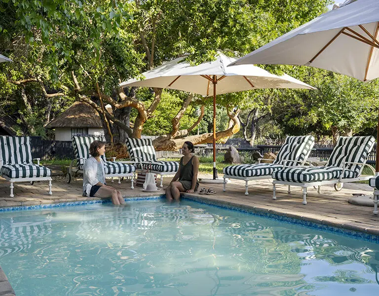 The swimming pool, lined by cushioned loungers.