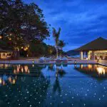 Iluminación ambiental nocturna alrededor de la piscina.