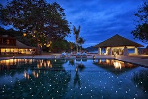 Iluminación ambiental nocturna alrededor de la piscina.