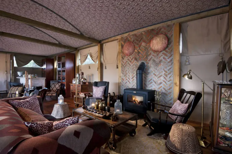 Un salón con chimenea de leña acristalada.