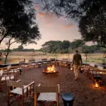 Disfrute de las bebidas habituales antes de la cena alrededor de la hoguera de Phinda Vlei, e incluso podrá avistar algún animal al atardecer | AndBeyond Phinda Vlei