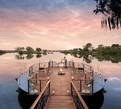 Sip sundowners while taking in the view of the Zambezi River at Thorntree River Lodge.