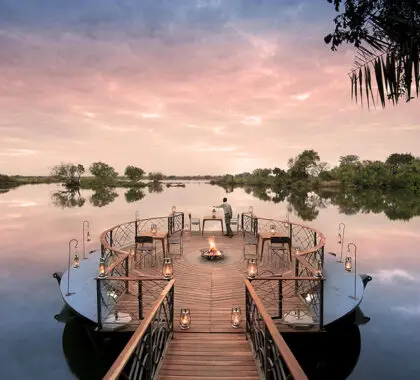 Sip sundowners while taking in the view of the Zambezi River at Thorntree River Lodge.