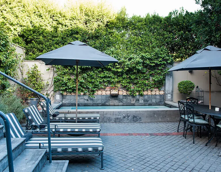 The swimming pool and cushioned loungers in the courtyard. 
