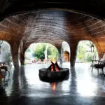 The central area of the lodge is exceptionally striking, with high reeded walls and an open boma-style firepit.
