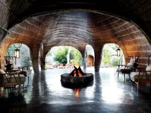 The central area of the lodge is exceptionally striking, with high reeded walls and an open boma-style firepit.
