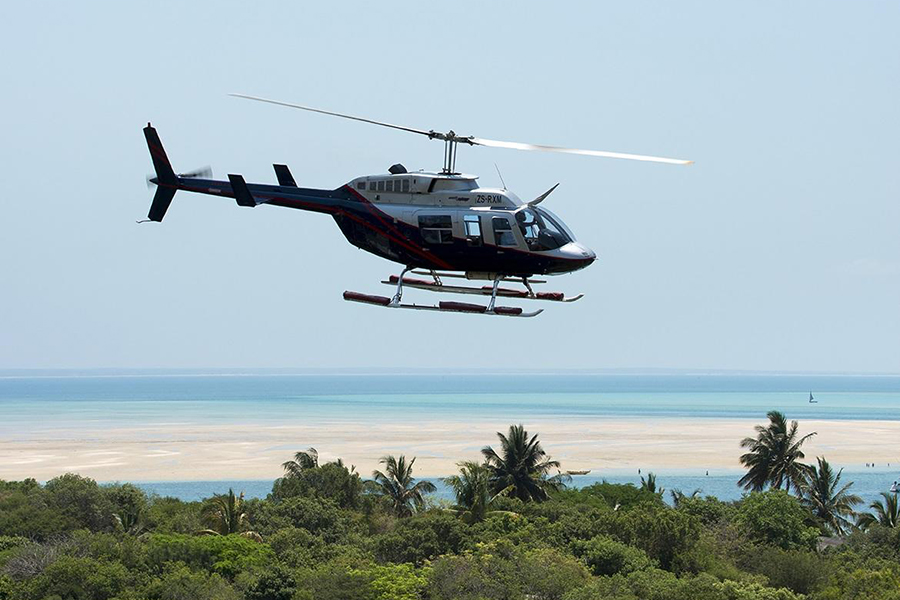 A helicopter soars over Benguela Island Lodge