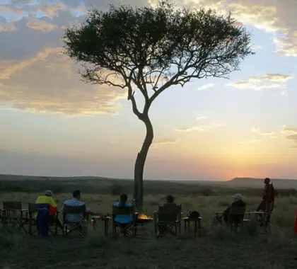 La mejor forma de disfrutar de una puesta de sol en el Masai Mara es en plena naturaleza, alrededor del fuego.