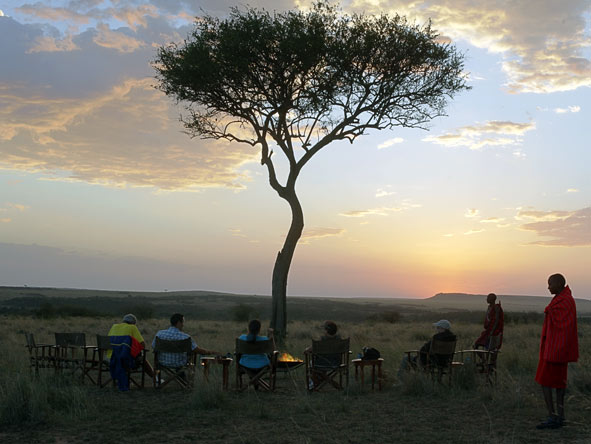 The best way to experience a sunset over the Masai Mara is out in the wilderness around the fire.
