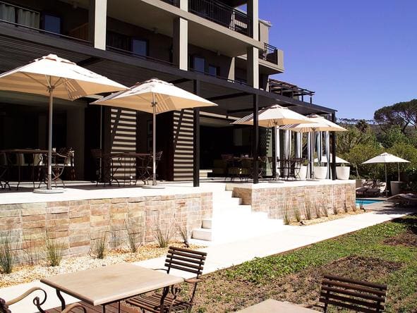 Siéntese a degustar deliciosos platos del Cabo en el elegante comedor y jardín al aire libre del hotel.