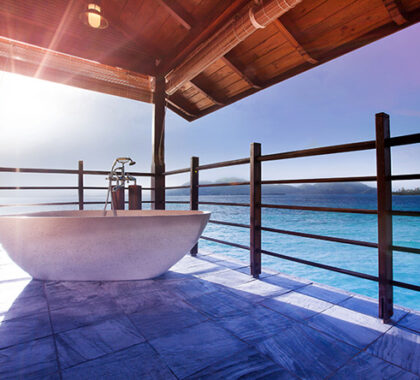 Enjoy an early morning bubble bath while the sun rises in the sky, turning the blue sea a brilliant shade of turquoise.