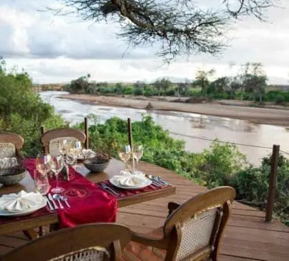 Disfrute de una cena con vistas al río Uaso Nyiro .
