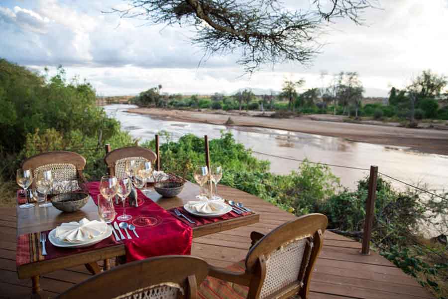 Disfrute de una cena con vistas al río Uaso Nyiro .