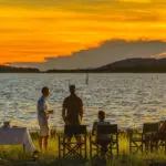 Guests gather on shore for sundowners.
