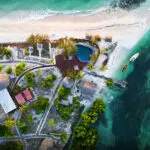 Una vista aérea del Coral Lodge muestra cómo a un lado está el océano y al otro la laguna. ¡Un paraíso para los amantes del agua!