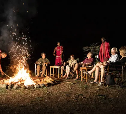 Comparta historias sobre las aventuras del día alrededor de la hoguera en el campamento Porini Lion Camp.