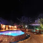 The pool area at night is the perfect setting for enjoying a delicious African culinary experience.