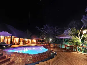 The pool area at night is the perfect setting for enjoying a delicious African culinary experience.