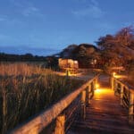 Wooden walkways are lit up at night, providing safe guidance back to your bungalow.