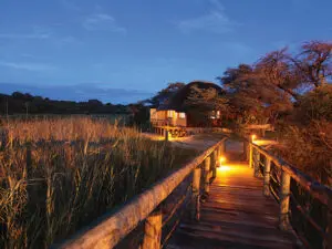 Wooden walkways are lit up at night, providing safe guidance back to your bungalow.