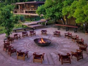 As the sun begins to set, gather around the festive campfire with a tipple of your choice.