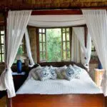 The beds are draped with mosquito nets and have large windows that overlook the lush garden.