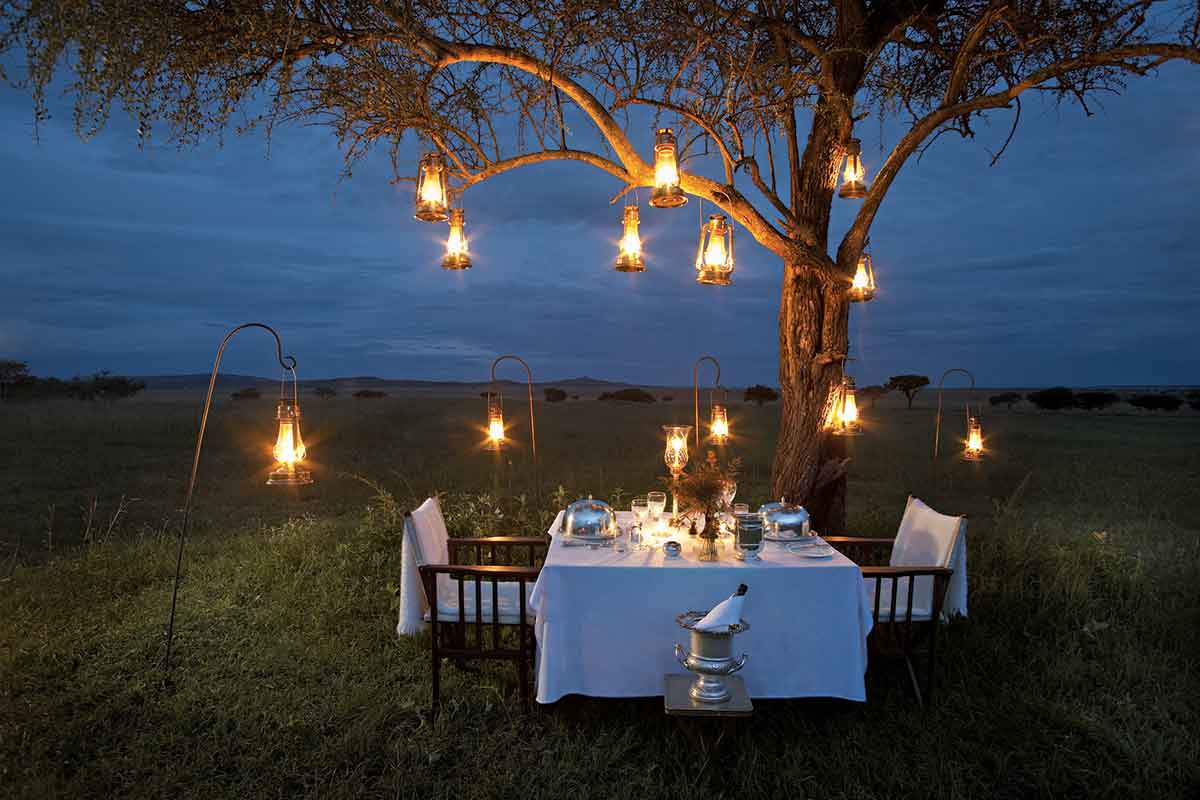 Romantic bush dinner under a tree at Singita Sabora Tented Camp, Tanzania