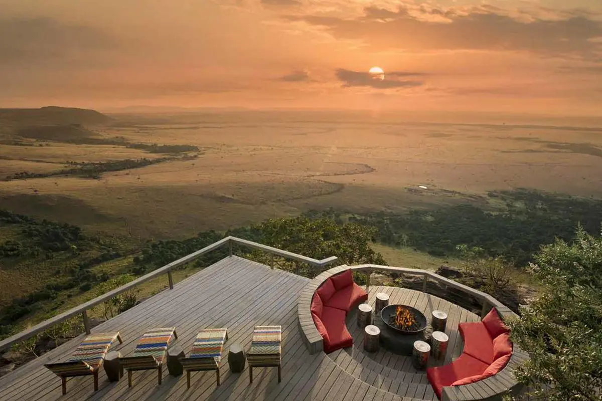 A large deck with sunken boma and several loungers raised high above the plains enjoy a spectacular view of a setting sun | Go2Africa