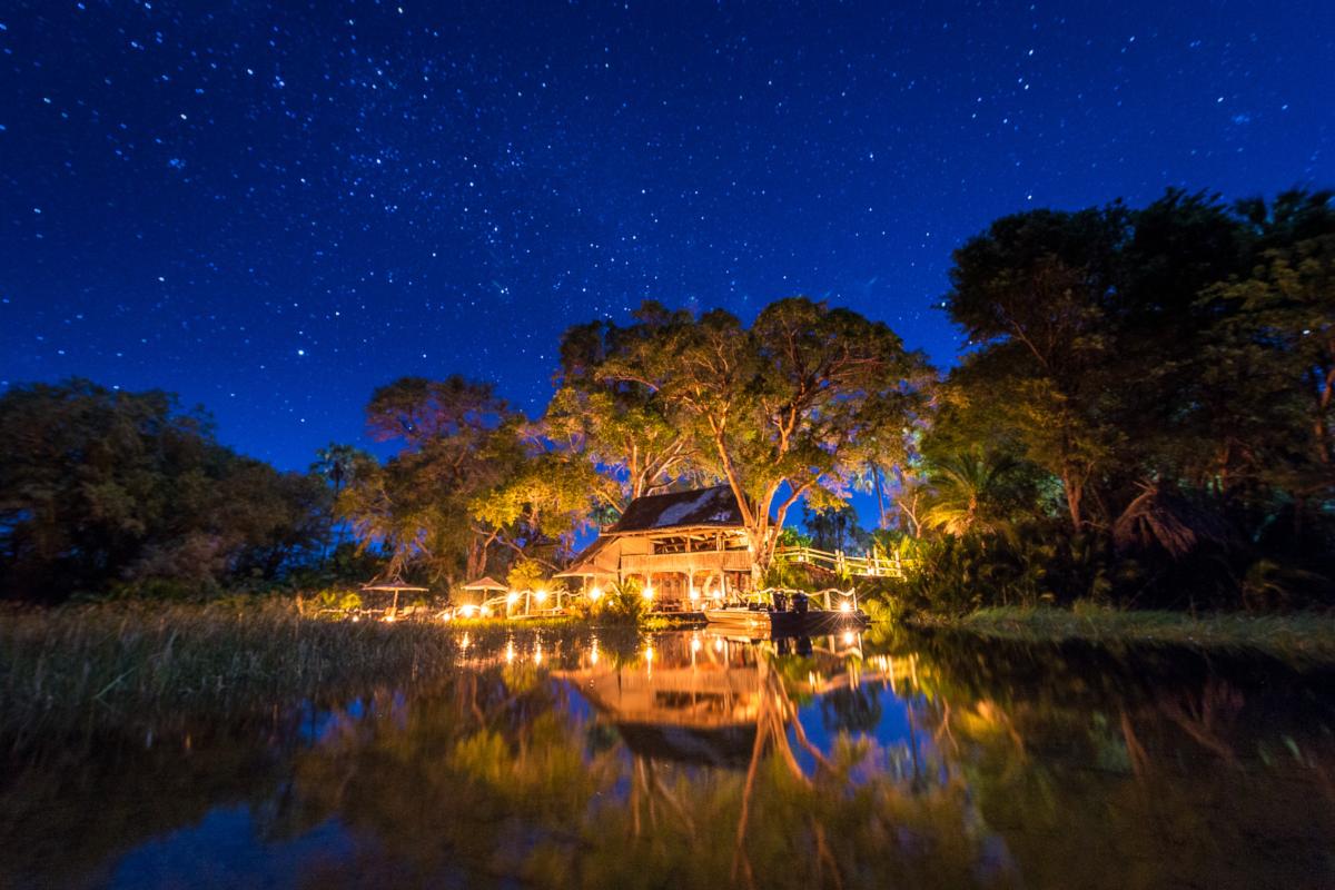 Night time exterior view of the intimate & luxurious Jacana Camp in the Okavango Delta