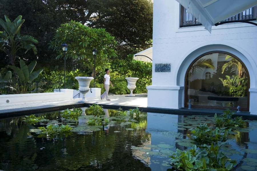 En primer plano de la imagen aparece un gran estanque, mientras que al fondo se ve el edificio del balneario Oyster Box | Go2Africa