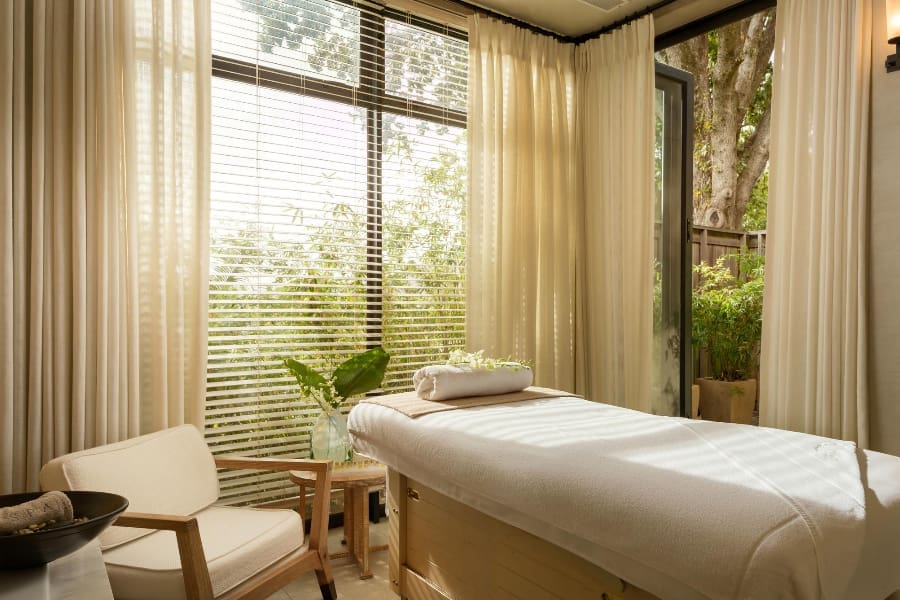 Una habitación luminosa con una cama de masaje en el centro en Delaire Graff Estate | Go2Africa