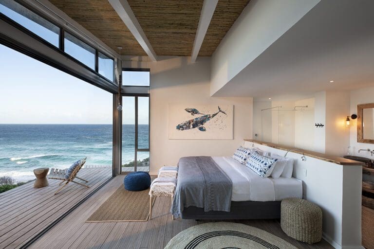 Ventanas de cristal del suelo al techo con vistas al Océano Índico y a la vida marina. 