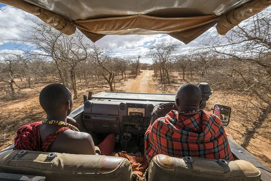 Two Masaai guides sit in the front of a game vehicle taking guests out on a drive to spot wildlife in Amboseli National Park | Go2Africa