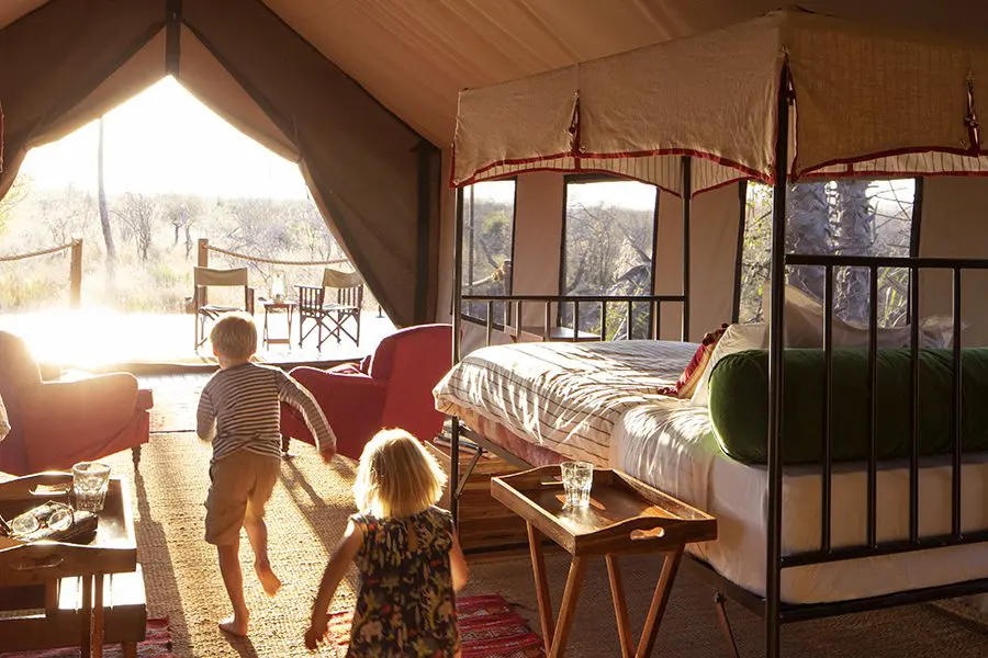 Los niños corren por una habitación soleada en Camp Kalahari 