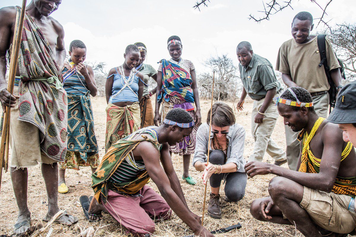 A group of locals teach a traveller to start a fire using traditional methods | Go2Africa