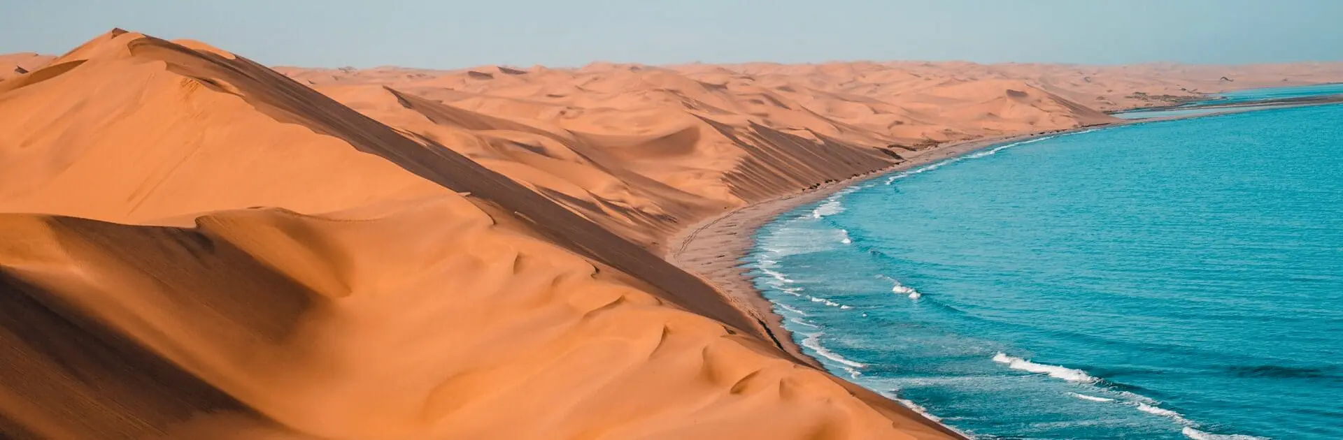 An aerial view of the red desert sand in Namibia meet the ocean | Go2Africa