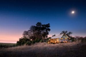 Exterior nocturno del Linyanti Bush Camp