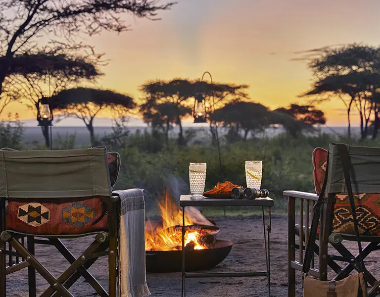Watch the sun set with a drink by a warm fire.