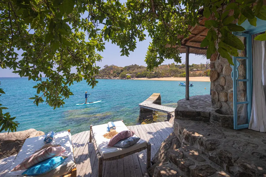 Views out from Kaya Mawa across Lake Malawi, a paddleboarder, and to the beach beyond | Go2Africa